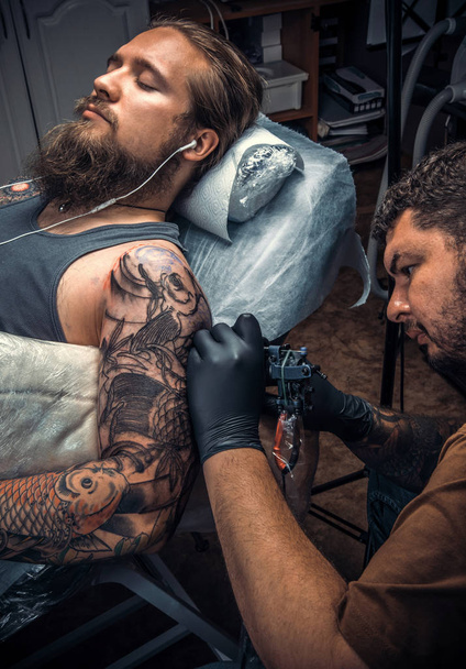 Tatuaje profesional posando en salón de tatuajes
 - Foto, Imagen