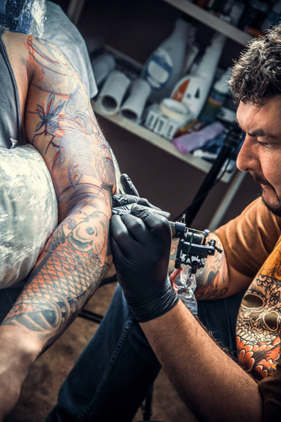 Especialista en tatuajes crear tatuaje en salón de tatuaje
 - Foto, Imagen