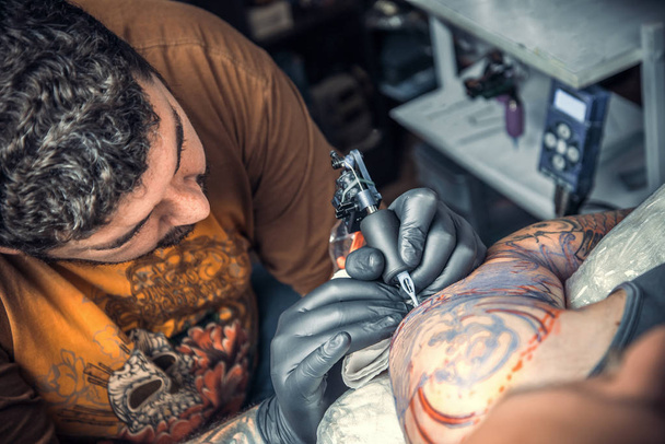 Професійний татуювання позує в тату-салоні / татуювання фахівець, що працює татуювання в студії татуювання
. - Фото, зображення