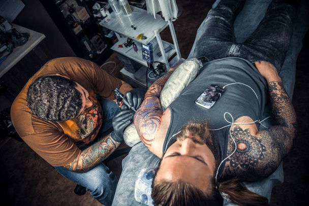 Maestro hace tatuajes en el estudio
 - Foto, Imagen