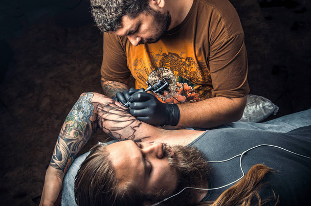 Maestro del tatuaje posando en salón de tatuajes
 - Foto, Imagen