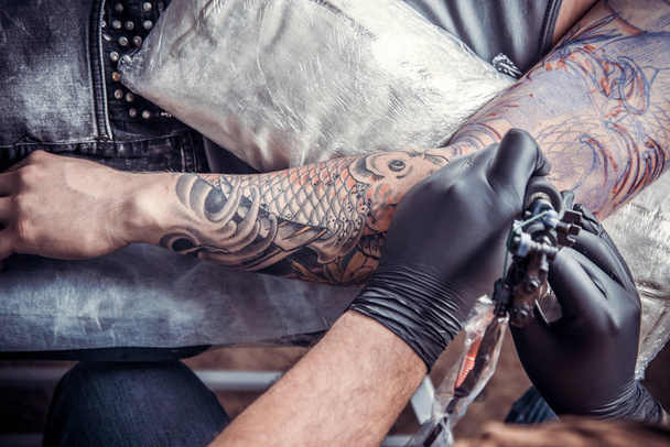 Tattoo master doing tattoo in tattoo parlor - Photo, Image