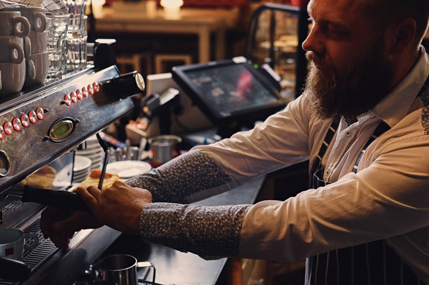 Bearded man is making coffee - Φωτογραφία, εικόνα