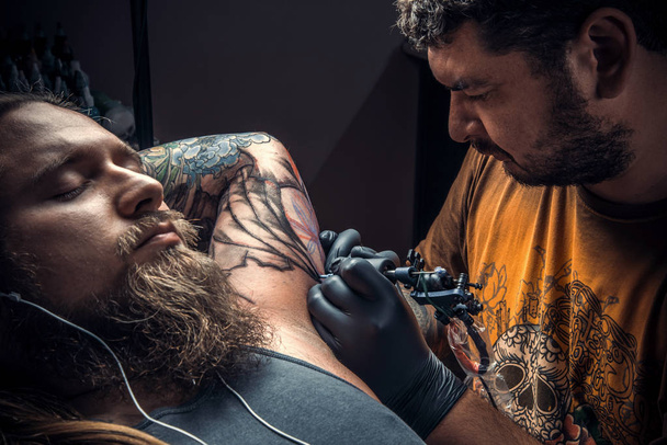 Tatoueur professionnel faisant un tatouage dans un studio de tatouage
 - Photo, image