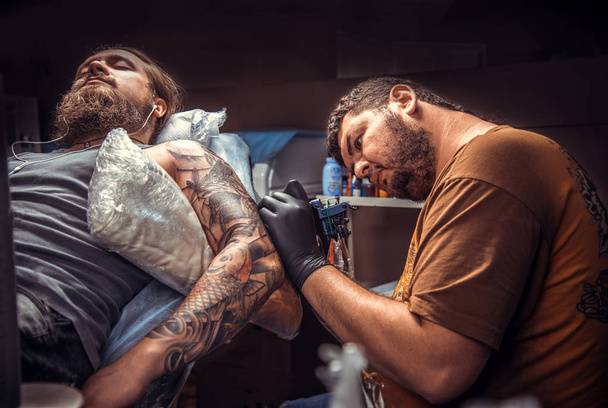 Tatuagem profissional no trabalho no estúdio de tatuagem
 - Foto, Imagem