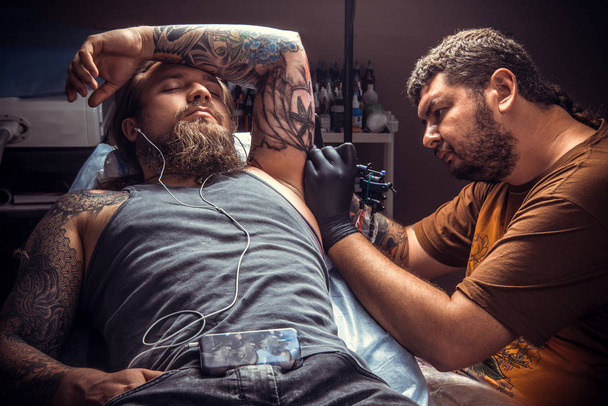 Professional tattooer create tattoo in tattoo studio - Foto, imagen