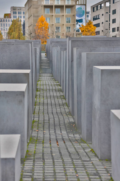 BERLIN - OCTOBER 02, 2016: Panoramic view of famous Jewish Holocaust Memorial near Brandenburg Gate in golden evening light with blue sky at sunset in summer in Berlin Mitte, Germany - Fotografie, Obrázek