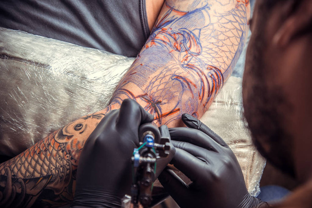 Professional tattooist at work in studio - Photo, Image