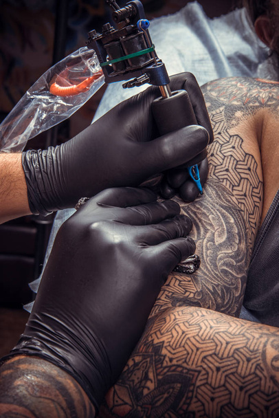 Майстер татуювання робить татуювання в татуювальному салоні
 - Фото, зображення