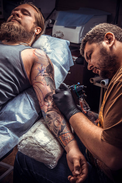 Tetováló mester a tetováló szalon a munka - Fotó, kép