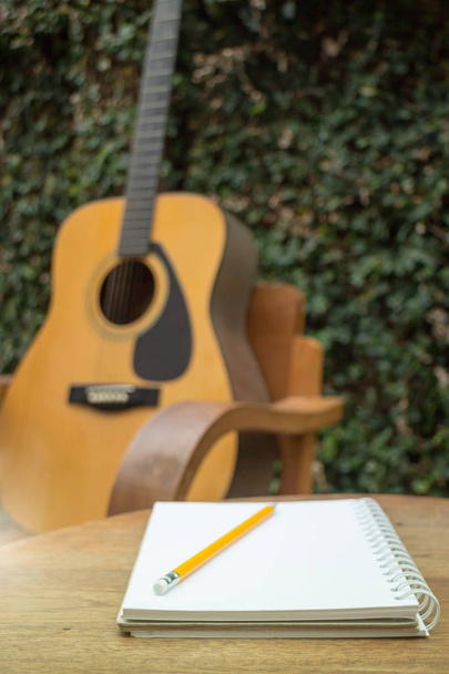 Żółta gitara akustyczna na drewnianym stole - Zdjęcie, obraz