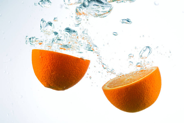 Orange in streams of water on a white background - Foto, imagen