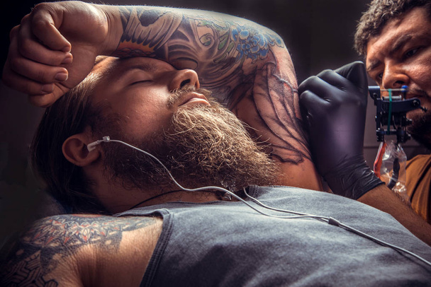 Maestro del tatuaje trabaja en salón de tatuajes
 - Foto, Imagen