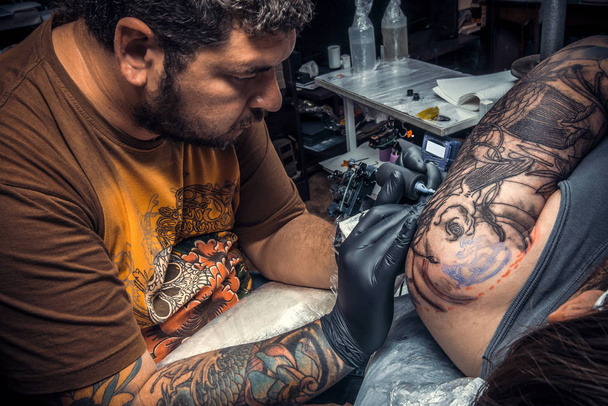 Tattooer のタトゥー パーラーで入れ墨をしています。 - 写真・画像