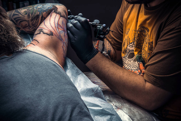 Tatuaje especialista trabaja en salón de tatuajes
 - Foto, Imagen
