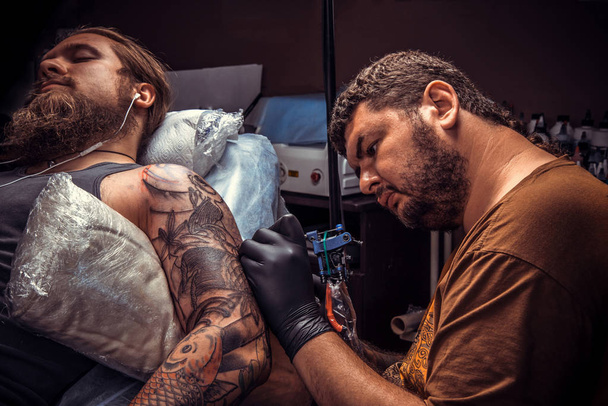 Professional tattooist posing in studio - Fotó, kép