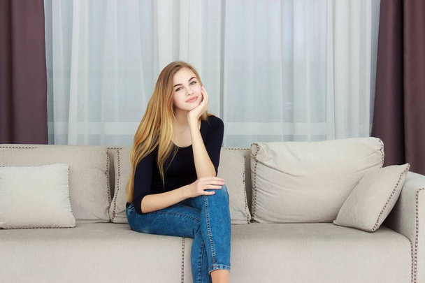 Csinos fiatal lány pihentető a kanapén, otthon - Fotó, kép