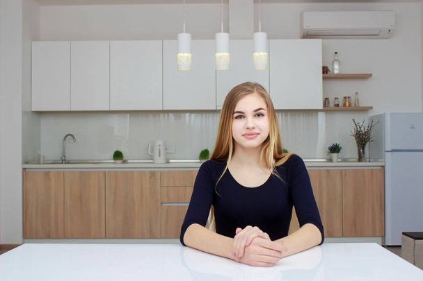 Young woman sitting a table in the kitchen - Foto, Imagem