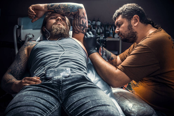 Tatuaje especialista hace tatuaje en salón de tatuaje
 - Foto, Imagen