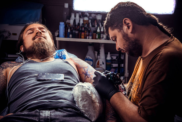 Tattooer serin dövme dövme salonunda yapar. - Fotoğraf, Görsel
