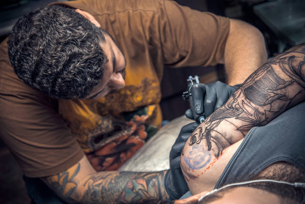 Maestro del tatuaje haciendo tatuaje en salón de tatuaje
 - Foto, Imagen