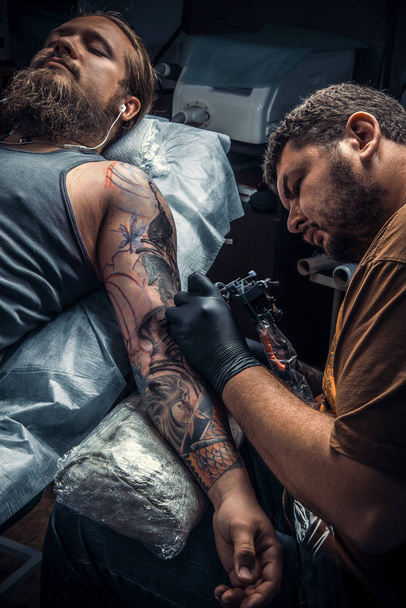 Tatuaje en el trabajo en el estudio de tatuajes
 - Foto, Imagen