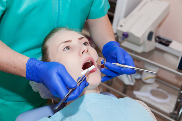 Tandarts die de tanden van een patiënt onderzoekt  - Foto, afbeelding
