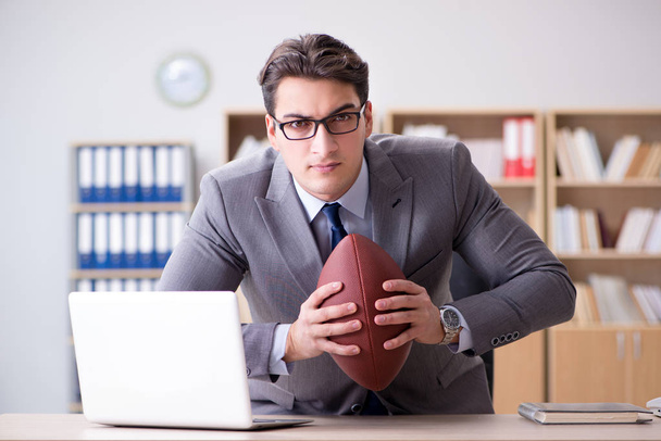 Επιχειρηματίας με αμερικανικό ποδόσφαιρο στο γραφείο - Φωτογραφία, εικόνα