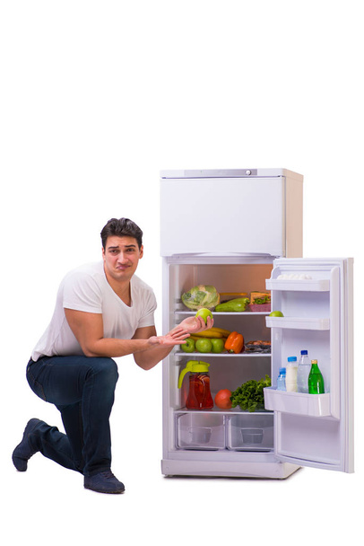 Ο άνθρωπος δίπλα στο ψυγείο γεμάτο τρόφιμα - Φωτογραφία, εικόνα