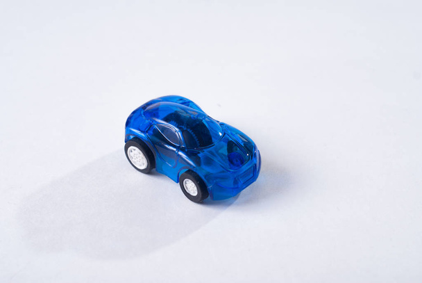 Jouet en plastique bleu voiture sur fond blanc, conception simple, jouet pour enfants
 - Photo, image