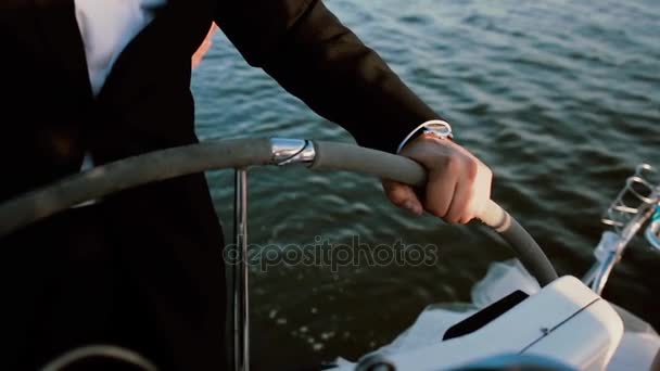 Vista ravvicinata di mani maschili in piedi dietro il volante sullo yacht. Giovane uomo d'affari a riposo con hobby preferito
. - Filmati, video