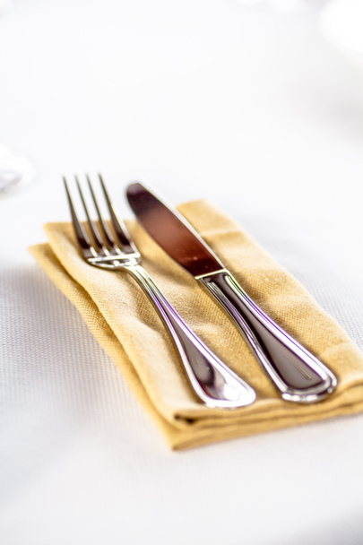 Fork and knife laying on a napkin on the table. - Foto, immagini