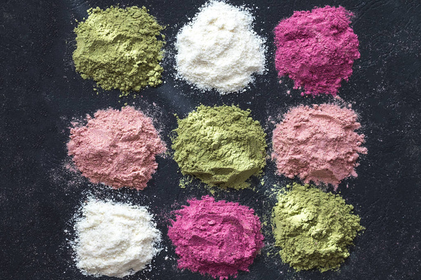 Various colorful superfood powders on dark background. Healthy food supplements, detox concept. Top view - Photo, Image