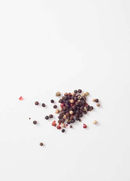 Red, white, black pepper peas on white - Φωτογραφία, εικόνα