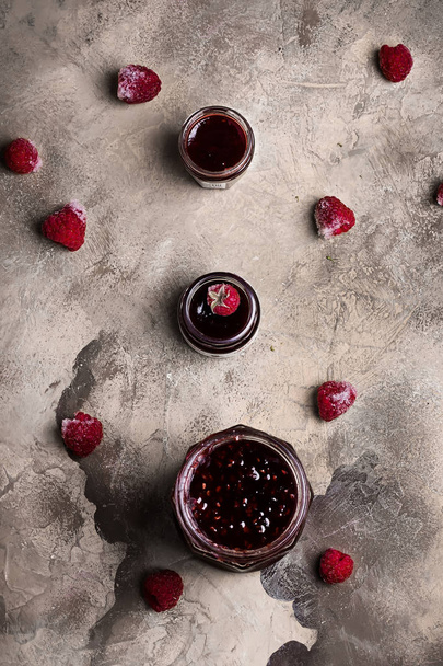 Raspberry jam on grunge background of concrete in vintage rustic style top view flat lying - Foto, imagen