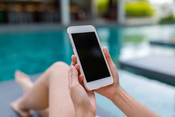 Woman using cellphone in swimming pool - Photo, Image