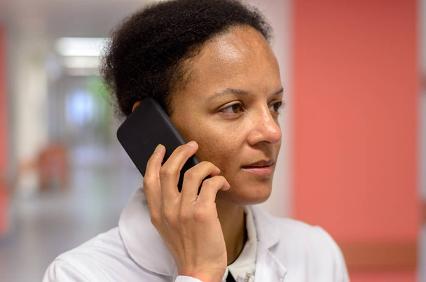 Médica mulher falando em um telefone celular
 - Foto, Imagem