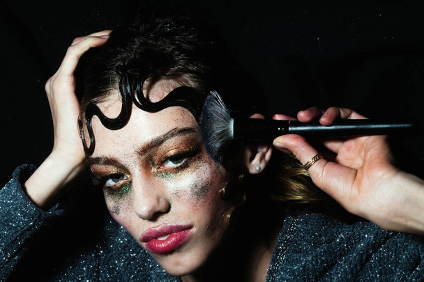Pretty fashion girl putting holiday glitter makeup - Zdjęcie, obraz
