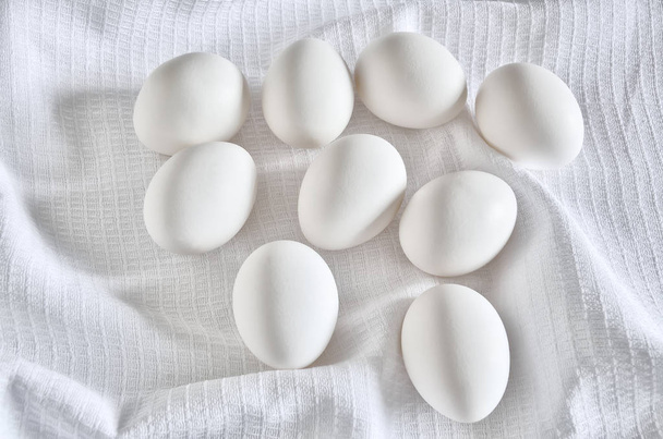 Huevos blancos frescos cerca de la toalla de algodón
 - Foto, Imagen