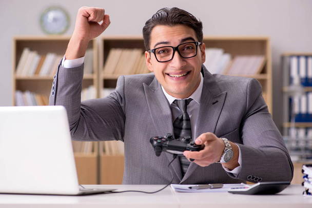 Businessman playing computer games at work office - Photo, Image