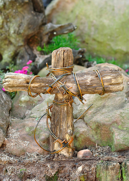 Una croce di legno avvolta in filo spinato in un giardino per Pasqua
  - Foto, immagini