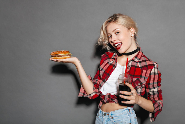  woman holding burger and glass of coke - Фото, зображення