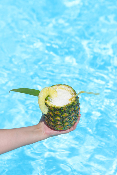  Hand with Pineapple exotic coctail near swimming pool - Fotoğraf, Görsel