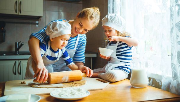 счастливая семья на кухне. мать и дети готовят тесто, ба
 - Фото, изображение