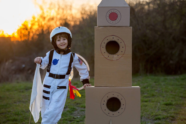 Schattige kleine jongen, gekleed als astronaut, spelen in de park - Foto, afbeelding