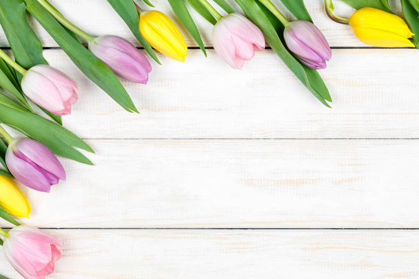 Bunch of pink and yellow tulips lying on a white wooden backgrou - Photo, image