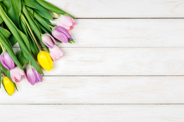 Bunch of colored tulips on a white wooden background - Foto, imagen