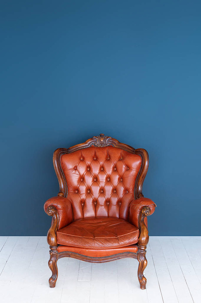 Урожай шкіряні розкіш коричневий крісло класичний коричневий шкіряний диван і старий синьому фоні. - Фото, зображення