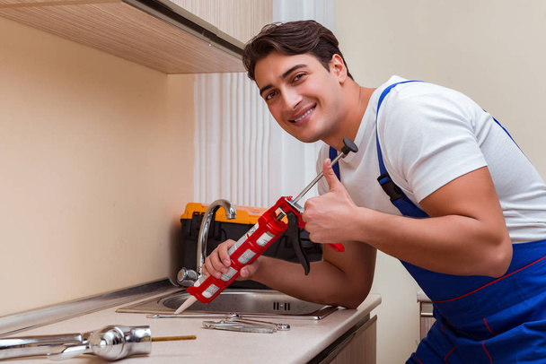 молодий ремонтник працює на кухні
 - Фото, зображення