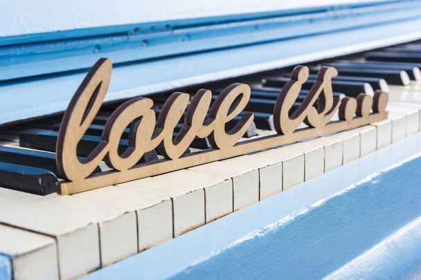 Modrá klavír detail s černé a bílé klávesy s textem láska je - Fotografie, Obrázek